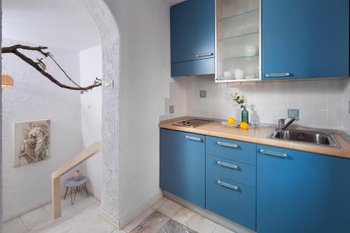 una cocina con armarios azules y fregadero en Villa Cissa Apartments by Irundo, en Rovinj