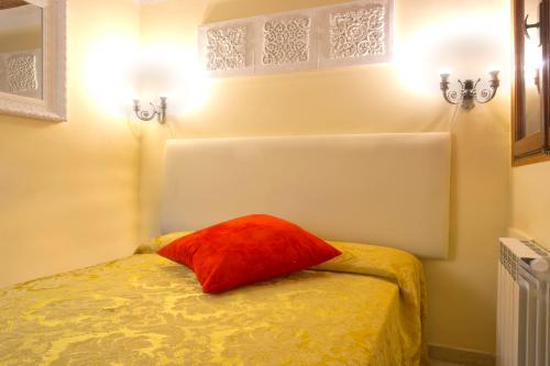 a room with a bed with a red pillow on it at Otto House Apartment in Venice