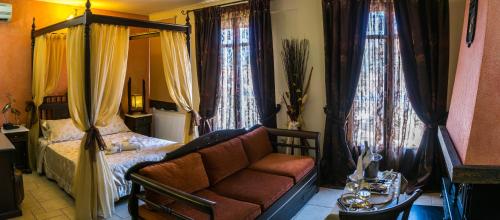 a bedroom with a bed and a couch and windows at ''EPAVLIS boutique GALAXIDI'' in Galaxidhion