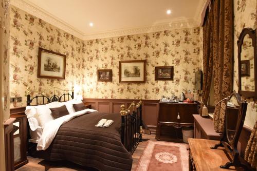 a bedroom with a bed and floral wallpaper at The Aston Tavern in Birmingham