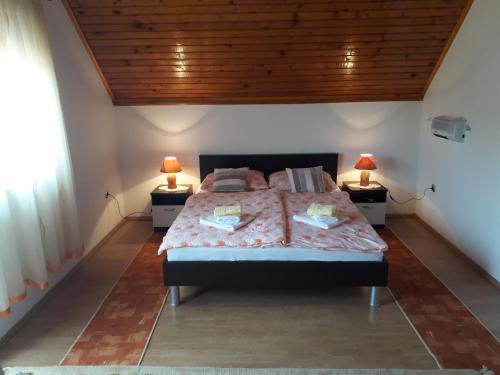 a bedroom with a bed with two lamps on two tables at Apartment Mrsinj in Korenica