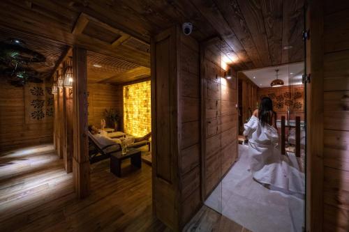 a woman in a white dress is walking through a room at Gold Hotel in Zakopane