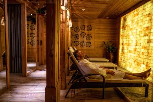a woman laying in a chair on a porch at Gold Hotel in Zakopane