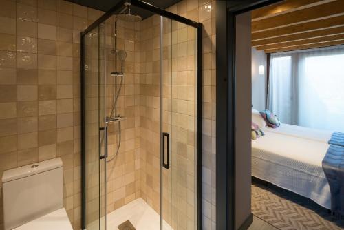 a shower with a glass door in a bathroom at Apartamentos La Santilar in Llanes