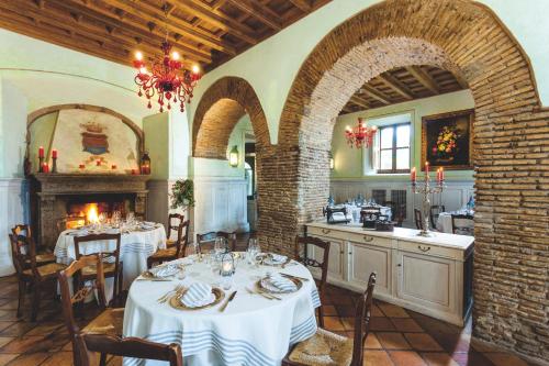 a dining room with two tables and a fireplace at Hotel La Locanda Dei Ciocca in Grottaferrata