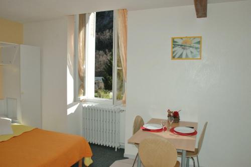 a small dining room with a table and a window at Appart Le Chili- Quartier thermal- Parc remarquable - Linge fourni in Luz-Saint-Sauveur