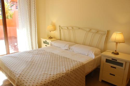 een slaapkamer met een wit bed en een raam bij PLAYA ANGEL in Estepona