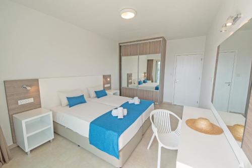 1 dormitorio con 1 cama grande y 1 mesa en La Casa Di Napa Apartments, en Ayia Napa
