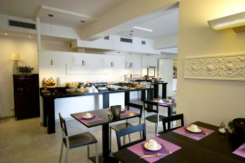um restaurante com mesas e cadeiras e uma cozinha em Hotel L'Approdo em Rapallo