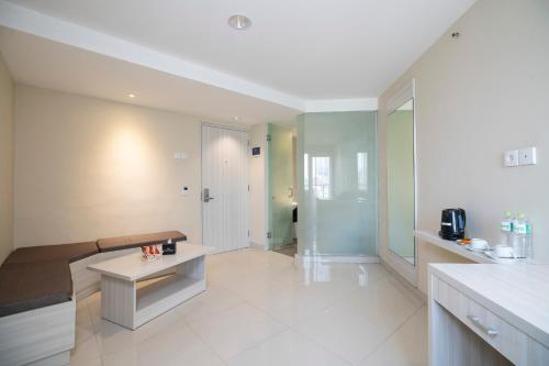 a large living room with a couch and a table at The Gloria Suites Grogol in Jakarta
