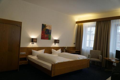 Habitación de hotel con cama y escritorio en Hotel zum Goldenen Ochsen, en Maikammer