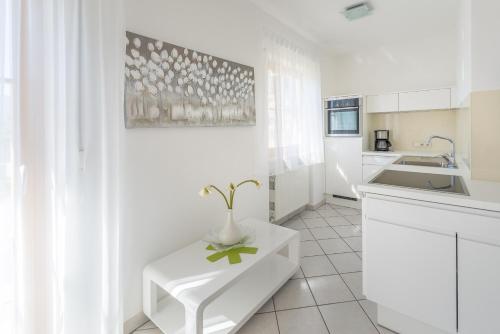 a white kitchen with a table and a sink at Ferienwohnungen Zwerger Reinhold in Termeno