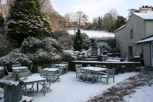 a patio with tables and chairs in the snow at The Punch Bowl Inn in Kendal