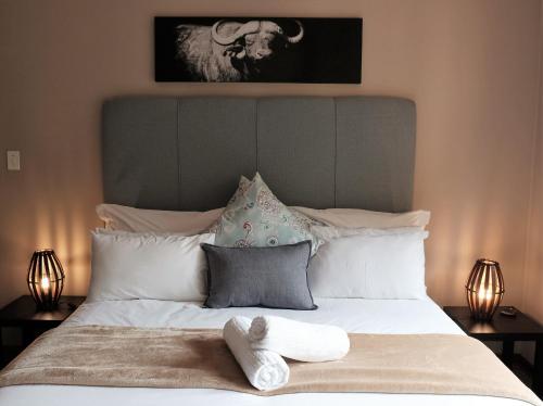 a bed with two towels on it with two lamps at Goedehoop Boutique Manor House in Malelane