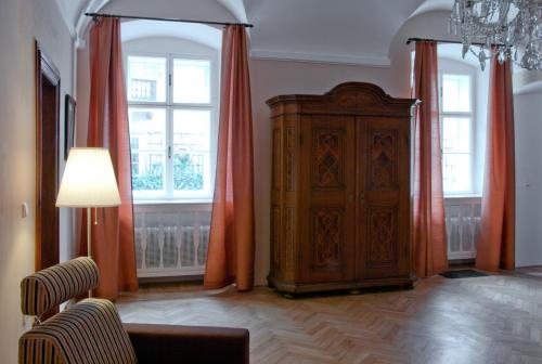 a living room with a large wooden cabinet and red curtains at Zámek Nové Město nad Metují in Nové Město nad Metují