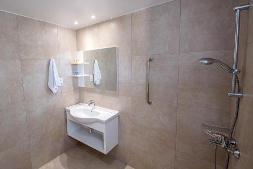 La salle de bains est pourvue d'un lavabo et d'une douche. dans l'établissement La Casa Di Napa Apartments, à Ayia Napa