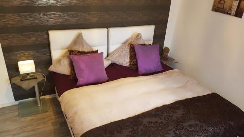 a bedroom with a large bed with purple pillows at Angelika's Gästehaus in Blieskastel
