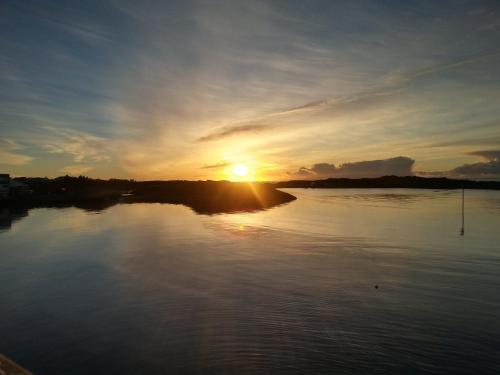 een zonsondergang boven een rivier met zonsondergang bij Seaview apartment Karmøy in Sæveland