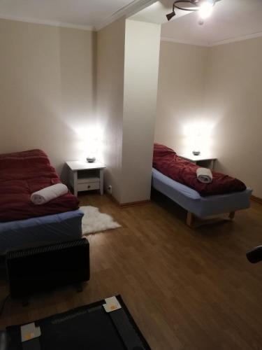 a room with two beds and two tables in it at Seaview apartment Karmøy in Sæveland