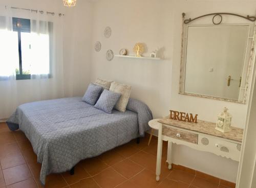 サアラ・デ・ロス・アトゥネスにあるAtlanterra Playaのベッドルーム1室(ベッド1台、鏡、テーブル付)