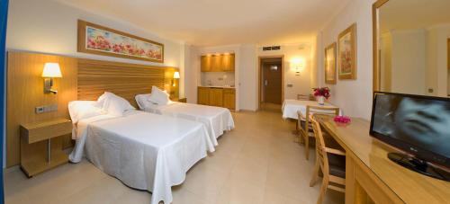 a hotel room with two beds and a flat screen tv at Bon Sol Prestige - AB Group in Playa d'en Bossa