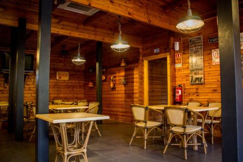 een restaurant met houten wanden en tafels en stoelen bij xisto camping in Janeiro de Baixo
