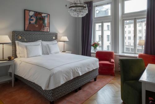 a bedroom with a large bed and a red chair at The Sparrow Hotel in Stockholm
