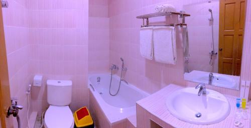 a bathroom with a sink and a toilet and a tub at Inle Star Hotel in Nyaung Shwe