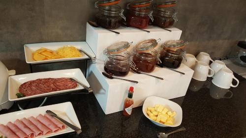 a table topped with different types of food in containers at Bella Luna Bed and Breakfast in Walvis Bay