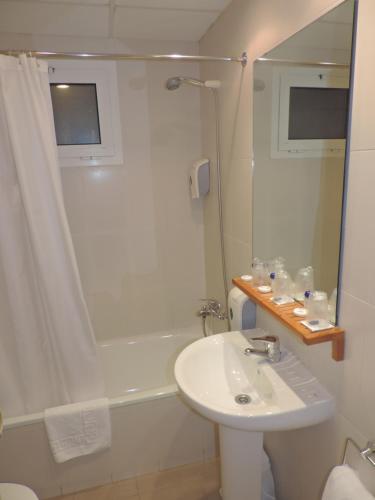 a white bathroom with a sink and a shower at Puerta De España in La Jonquera