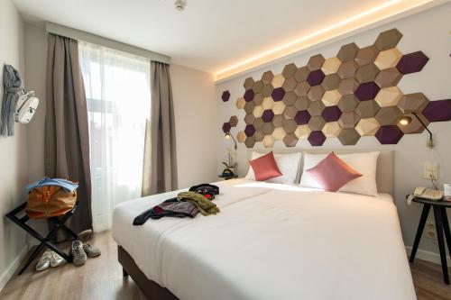 a bedroom with a large white bed and a window at Three Corners Hotel Art in Budapest