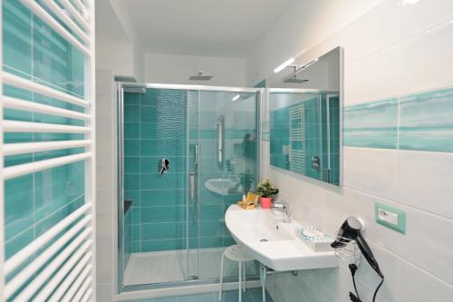 uma casa de banho com um lavatório e uma cabina de duche em vidro. em B&B Valentì em Amalfi
