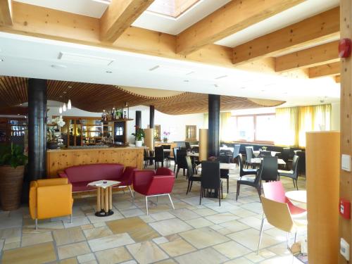 a restaurant with wooden ceilings and tables and chairs at Sporthotel Rasen in Rasùn di Sotto