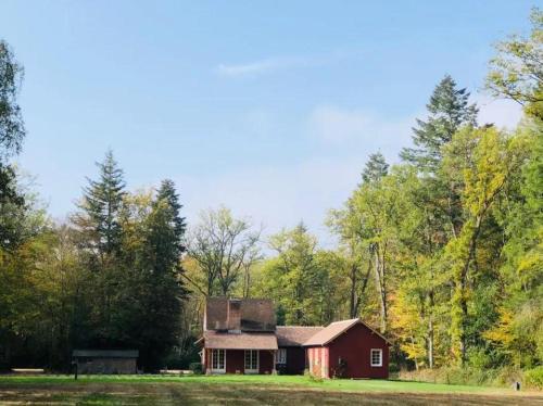 Une ancienne grange rouge au milieu d'un champ dans l'établissement Maison canadienne, à Salbris