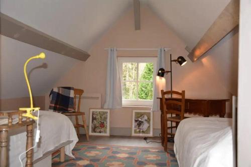 a attic bedroom with a bed and a window at Maison canadienne in Salbris