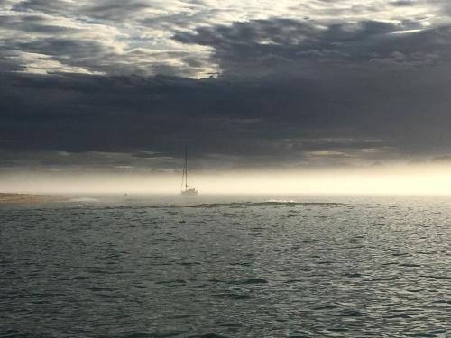 a sail boat in the water under a cloudy sky at hotel la trainera in Pedreña