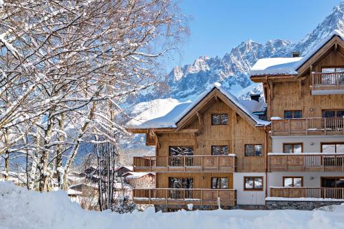 a lodge in the snow with snow covered trees at MGM Hôtels & Résidences - Résidence Chalets Elena in Les Houches