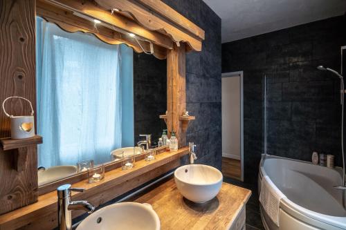 a bathroom with two sinks and a tub and a tubermott at Bright airy spacious apartment in Passy