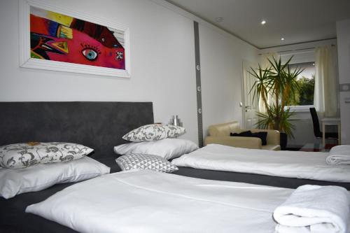 a hotel room with three beds with white sheets at Villaci Business Apartments in Leimen