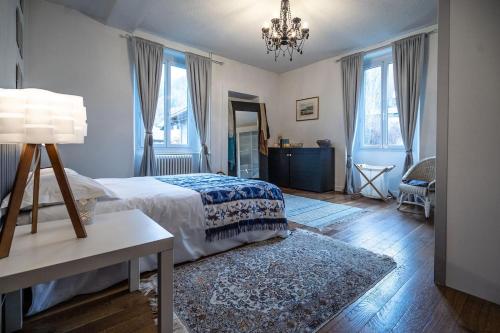 a bedroom with a bed and a table and windows at Bright airy spacious apartment in Passy