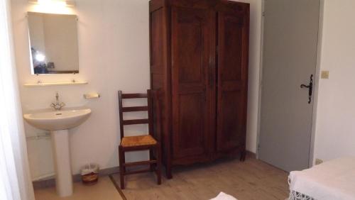 a bathroom with a sink and a wooden door at L'Oustau in Cavaillon