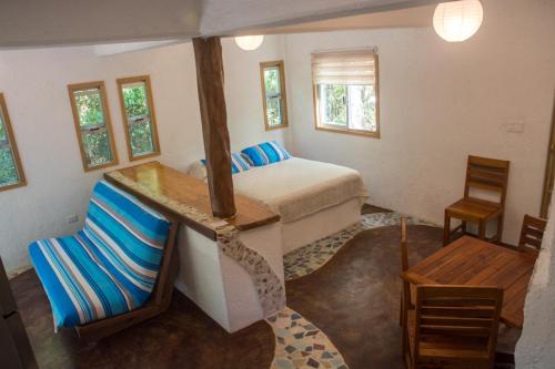 a bedroom with a bed and a table and a chair at Bungalow Bé La Kin in Cozumel