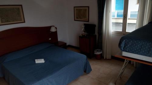 リド・ディ・イエゾロにあるHotel Heronのベッドルーム(青いベッド1台、窓付)
