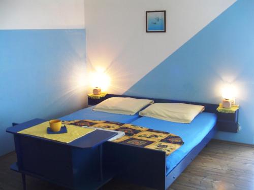 ein blaues Schlafzimmer mit einem Bett und zwei Lampen in der Unterkunft Apartments Ana&Nešo in Pakoštane