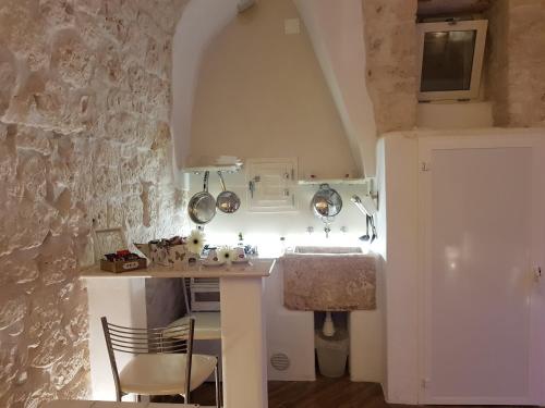 una cucina con lavandino e tavolo con sedia di Alloggio Turistico Suite Nino a Ceglie Messapica