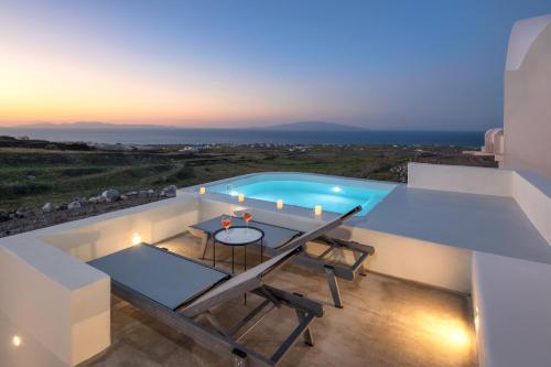 a villa with a swimming pool at night at Aplada Suites in Oia