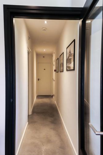 a hallway with white walls and a black framed mirror at Bij Jans in Hilvarenbeek