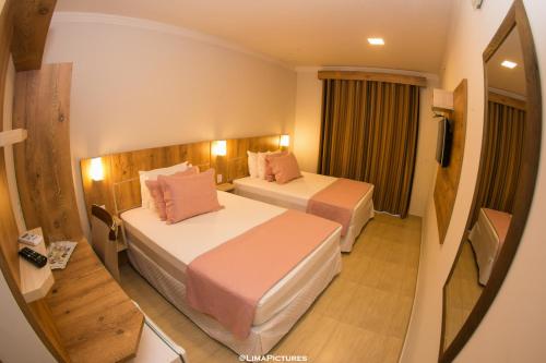 佩尼亞的住宿－Pousada Villarejo Armação，酒店客房,设有两张床和镜子