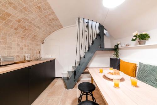 une cuisine et une salle à manger avec une table et un escalier dans l'établissement Architect's Triplex - Haut Marais, à Paris