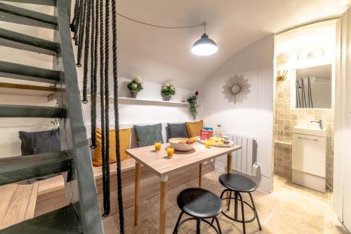 - une petite salle à manger avec une table et deux tabourets dans l'établissement Architect's Triplex - Haut Marais, à Paris
